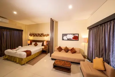 a hotel room with two beds and a couch at The Mupu Seminyak in Seminyak