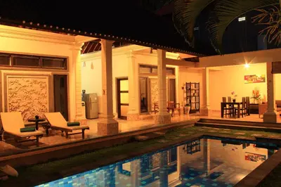 a house with a swimming pool at night at The Mupu Villa Seminyak in Seminyak