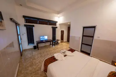 a large room with a bed and a television at The Mupu Villa Seminyak in Seminyak