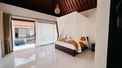 a bedroom with a bed and a large window at UCU VILLAGE at ULUWATU JIMBARAN in Jimbaran