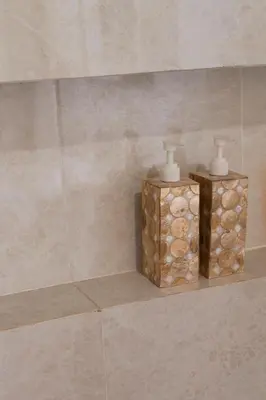 two candles sitting on a shelf in a bathroom at UCU VILLAGE at ULUWATU JIMBARAN in Jimbaran