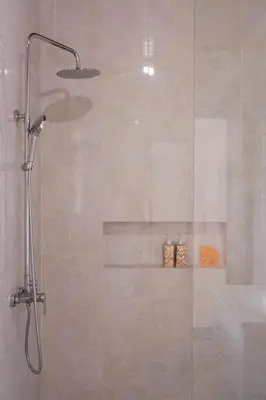 a shower with a glass door with a sink at UCU VILLAGE at ULUWATU JIMBARAN in Jimbaran