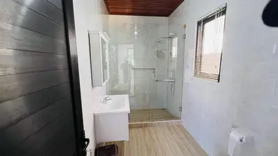 a white bathroom with a sink and a shower at UCU VILLAGE at ULUWATU JIMBARAN in Jimbaran