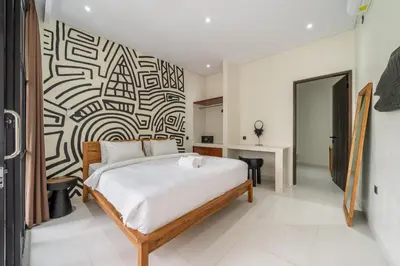 a bedroom with a bed and a black and white patterned wall at Alisa 4 - Luxurious 4BR Villa with Garden Views and Pool in Seminyak