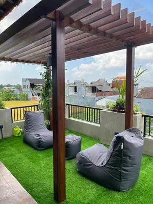 a pergola with two bean bags on the grass at Wakajima House kuta Utara in Kerobokan