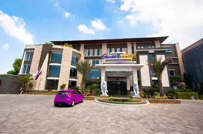 a purple car parked in front of a building at Quest San Denpasar by ASTON in Denpasar