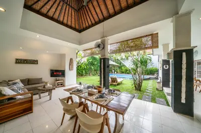 an open living room with a table and chairs at Villa Kangaroo Seminyak next to double six beach in Seminyak