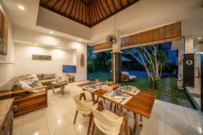 a dining room and living room with a table and chairs at Villa Kangaroo Seminyak next to double six beach in Seminyak