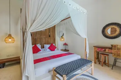 a bedroom with a canopy bed and a table at Luxury 3BR Villa Daenerys Pool Ricefield Family-Friendly Near Canggu in Kerobokan