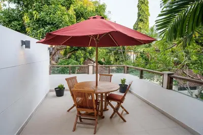 a table and chairs with an umbrella on a balcony at Villa Orange 2BR Seminyak by Exotic Bali Properties in Badung