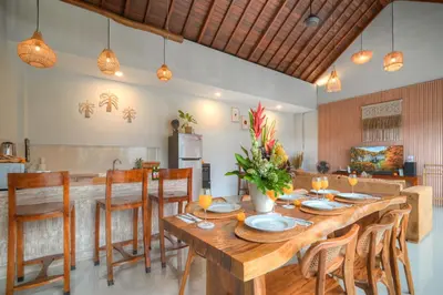 a dining room with a wooden table and chairs at Villa O'Anne II in Seminyak
