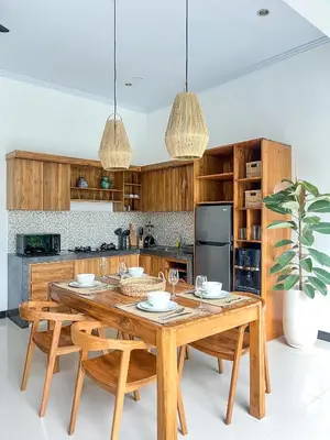 a kitchen with a wooden table and some chairs at Luxe 2Bedrooms D Villa Berawa - Near Beach,FINNS & ATLAS in Canggu