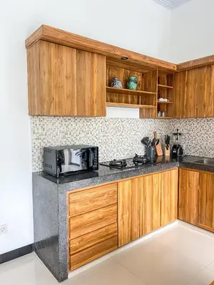 a kitchen with wooden cabinets and a microwave at Luxe 2Bedrooms D Villa Berawa - Near Beach,FINNS & ATLAS in Canggu