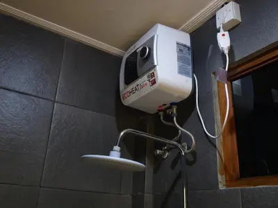 a hair dryer on the wall of a bathroom at Ken Ken Guest House in Seminyak