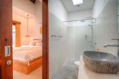 a bathroom with a tub and a bedroom with a bed at Villa Bella Wilson III in Seminyak