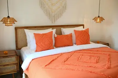 a bed with orange and white pillows on it at Villa Bella Wilson III in Seminyak