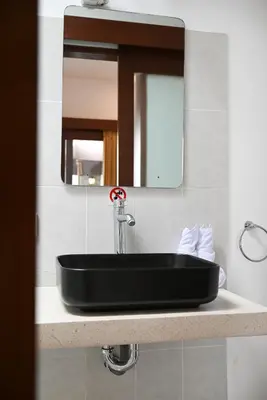 a black sink sitting on a counter under a mirror at Villa Bella Wilson III in Seminyak