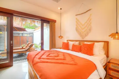 a bedroom with a bed with an orange blanket at Villa Bella Wilson III in Seminyak