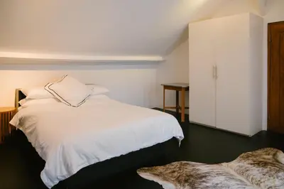 a bedroom with a white bed and a white cabinet at Villa Kubu Lebak 3 in Seminyak