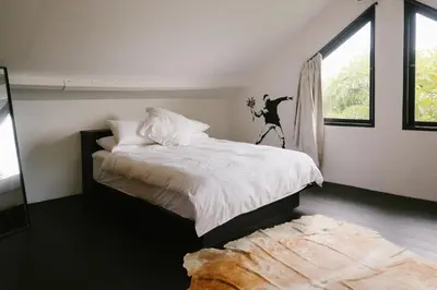 a bedroom with a large bed and a window at Villa Kubu Lebak 3 in Seminyak