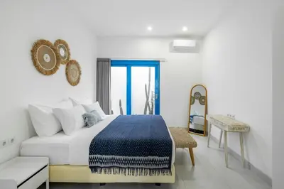 a white bedroom with a bed and a couch at Casa Posa Seminyak in Seminyak