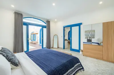 a bedroom with a blue and white bed and a mirror at Casa Posa Seminyak in Seminyak