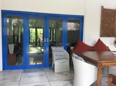a patio with blue doors and a table and chairs at Your Tropical Oasis Mason Villas Seminyak in Seminyak