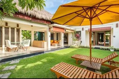 a backyard with a table and an umbrella at 4 Bedroom Private Villa Umalas 2 in Seminyak