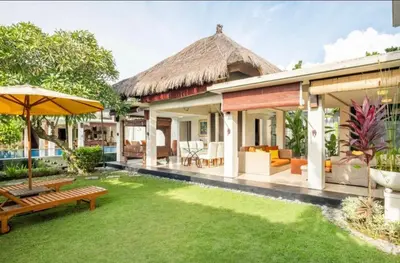 a house with a grass yard with aconservancyconservancy at 4 Bedroom Private Villa Umalas 2 in Seminyak