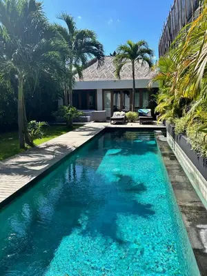 a swimming pool in the backyard of a house with palm trees at Top Villa Ilo, best area near canggu 250 m2 on 750 m2 land in Kerobokan