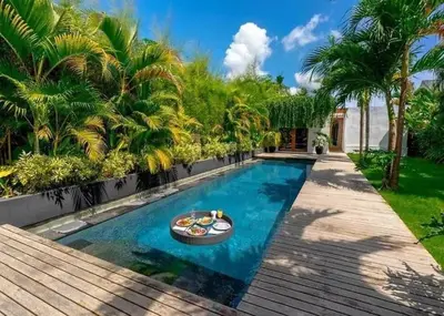 a swimming pool with a table in the middle at Top Villa Ilo, best area near canggu 250 m2 on 750 m2 land in Kerobokan