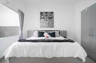a bedroom with a white bed with a white comforter at Aster Villa by iBali Management in Legian