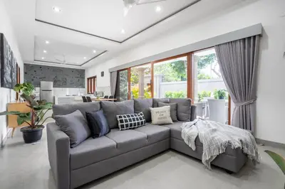 a living room with a large gray couch at Aster Villa by iBali Management in Legian
