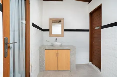 a bathroom with a sink and a mirror at Melati Villa by iBali Management in Legian