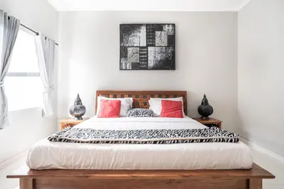 a bedroom with a large bed with red pillows at Melati Villa by iBali Management in Legian