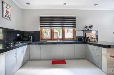 a kitchen with white cabinets and a window at Melati Villa by iBali Management in Legian