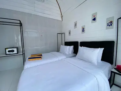 two beds sitting next to each other in a room at HK Villa Family in Seminyak