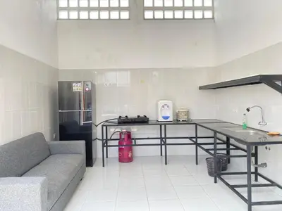 a kitchen with a table and a couch in a room at HK Villa Family in Seminyak
