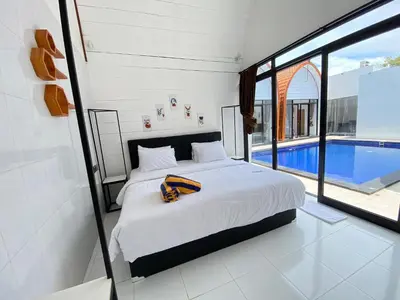 a bedroom with a bed and a swimming pool at HK Villa Family in Seminyak