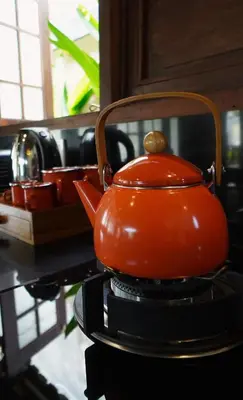 an orange tea kettle sitting on top of a table at Oemah Djoglo Kerobokan in Kerobokan