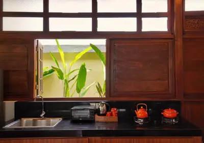 a kitchen counter with a sink and a window at Oemah Djoglo Kerobokan in Kerobokan