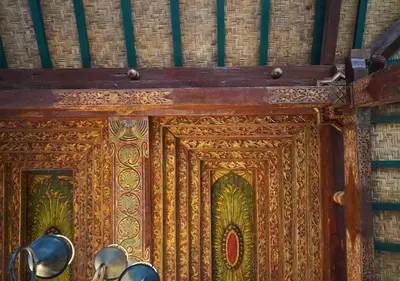 an ornate wooden door with bells on a wall at Oemah Djoglo Kerobokan in Kerobokan