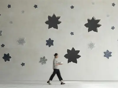 a woman walking past a wall with stars on it at Amnaya Resort Kuta in Kuta