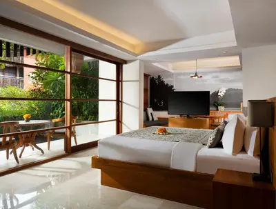 a bedroom with a large bed and a large window at Amnaya Resort Kuta in Kuta