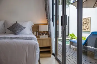 a bedroom with a bed and a sliding glass door at Villa Kumala Sari in Seminyak
