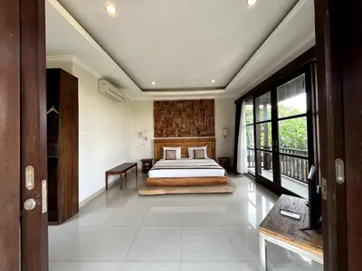 a bedroom with a bed in the middle of a room at White Lotus Villa by Miel Property in Seminyak