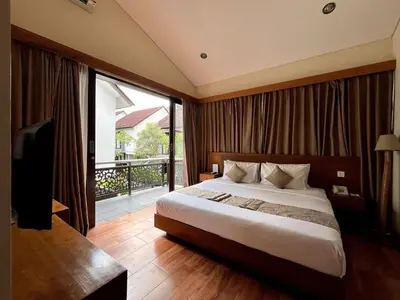 a bedroom with a large bed and a balcony at Grand Kesambi Family Villa by Miel Property in Seminyak