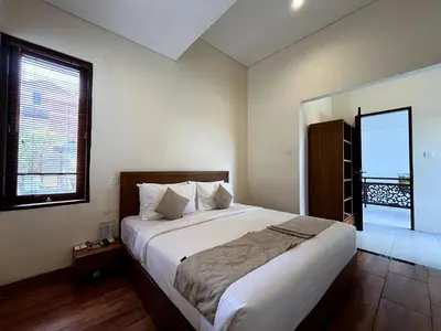 a bedroom with a large bed and a window at Grand Kesambi Family Villa by Miel Property in Seminyak