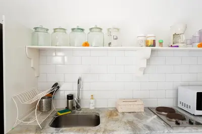 a kitchen with a sink and glass jars on a shelf at VILLA BELLA - 7Min Beach Access - 10min to Canggu in Canggu