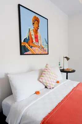 a bedroom with a painting of a woman sitting on a bed at VILLA BELLA - 7Min Beach Access - 10min to Canggu in Canggu